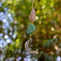 Macro detail of handmade crystal hanging ornament with moon pendant and braided rope - Rose Quartz + Green Fluorite (Silver Accessories)