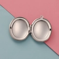 Macro view of a 316L stainless steel oval locket showing two internal photo slots - Silver Smooth Style