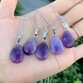 Five natural purple amethyst teardrop pendant necklaces with silver chains held in hand - Water Drop Amethyst