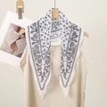 Detail showing white chiffon scarf with black paisley pattern tied on a vest collar - Black and White