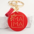 Macro shot of red wooden charm with MAMA engraving, gold keychain, and red tassel detail - Watermelon red