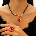 Detail of baroque gold necklace and ring set with red gems and black leather cord - Gold Branch Red Jewelry 2-Piece Set