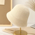 Women's cream knit bucket hat on a gold metal stand in a warm minimalist setting - M (56-58cm) / Off-white