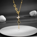 Elegante collana in titanio dorato con ciondoli a farfalla bianchi e neri e una perla - Oro