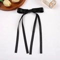 Elegant black satin ribbon bow hair clip with long streamers on a white background - Black