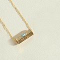 Collana dorata con pendente rettangolare malocchio e pietra blu su superficie beige - Ciondolo in Smalto Blu (XL2685-2)