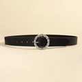 Close-up of black leather belt featuring a silver twisted metal buckle on beige background - Black