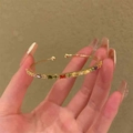 Polished gold cuff bracelet featuring vibrant rainbow baguette gemstones in a sleek open design - Open Rainbow Zircon Bangle