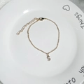 Detailed close-up of a 18K gold-plated bracelet with a zircon-set S-letter pendant - Letter S