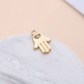 Detailed close-up of a golden Hamsa hand pendant with a sparkling crystal stone - Hamsa Hand Medium (7#)