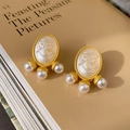 Vintage gold-toned cameo earrings with pearl drops shown on an elegant book page - Silver Earring Post Portrait Pearl Earrings