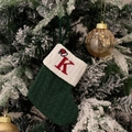 Green knit Christmas stocking with embroidered red letter K and Santa hat design - Green/Letter K