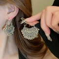 Detailed view of silver ethnic hollow earrings with delicate metal bead tassels on a model - 10# Fan Hollow Metal Bell (Silver)
