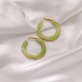 Détail de créoles en résine verte avec cadre doré sur fond de soie blanche - Vert Pâle
