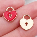 Red heart lock and textured gold pendant on fingertip showing size and detail - Red Heart Lock (11040)