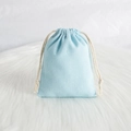 Light blue linen texture drawstring jewelry pouch on a soft white plush background - 7*9cm / Blue