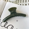 Macro shot of large dark green hair claw clip with glossy finish on a white art book - 11.5cm / Dark Green
