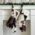 Detail of plush cow print Christmas stockings hanging on fireplace with festive decor - 20 inch / Lace Trim Cow Print