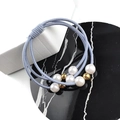 Gros plan sur élastique à cheveux bleu multi-brins avec perles blanches et billes dorées - Bleu ciel