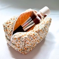 Quilted floral makeup bag with orange flower print and green leaves for travel storage - Orange