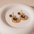 Dettaglio ravvicinato di orecchini vintage con pietra grigia e perle su vassoio bianco - Stile Ovale Perla Zirconia Oro (Ago d'Argento)