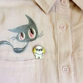 Détail d'une épinglette de chien de dessin animé sur une chemise rose avec broderie chat - Style Shih Tzu