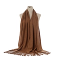 Close-up of camel cashmere-style scarf showing soft twill texture and tassel fringe detail - Dark Camel