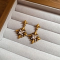 Macro view of vintage gold iris flower earrings with zircon stones on velvet tray - 925 Sterling Silver Earring Post - Vintage Style / Antique Gold