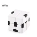 Macro shot of white infinity cube toy with black joints for stress relief and focusing - White