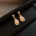 Macro shot of gold teardrop earrings with crystals on a black leather display tray - 16# Silver Needle-Golden Zirconia Teardrop