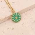 Detailansicht einer Goldkette mit grünem Emaille-Sonnenanhänger auf einer Steinfläche - Grüne Sonne Runde Medaille (2#)