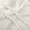 Polished round white natural shell beads for handmade jewelry on a textured white plate - 10mm (1 Strand/Approx. 40cm/39pcs)