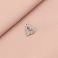 Detailed view of a silver heart-shaped pendant with a textured beaded border on pink cloth - 7# Hollow Heart Style