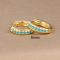 Macro shot of 8mm gold hoop earrings with blue cubic zirconia stones in a row - 8mm / Gold (Blue Zircon)