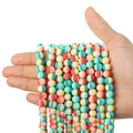 Bunte gestreifte Polymer-Ton-Rundperlen in der Hand für handgefertigte DIY-Schmuckarbeiten - Zweifarbig