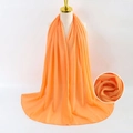 Solid orange pearl chiffon hijab scarf for women displayed on mannequin with fabric texture - Orange