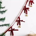 Festive red velvet bow with golden bells hanging on a decorated Christmas tree background - Wine Red Bow Garland