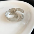 Makrodetail eines silbernen Metallarmreifs mit einer aufwendigen Phönix-Vogel-Gravur - Phönixmuster-Stil (8#) / Silber