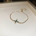 Détail du bracelet croix doré avec zircons verts et fermoir coulissant ajustable - Bracelet Réglable avec Pendentif Croix en Zircone Verte