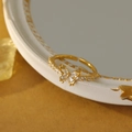 Macro shot of gold butterfly ring with sparkling pavé zircons and adjustable open band - 18K Gold