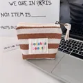 Close-up of small striped canvas makeup bag with sozakka beauté embroidery and zipper - Brown Stripes