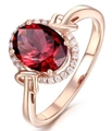 Elegant rose gold ring featuring a large oval red gemstone with a pavé diamond halo - Ur0523