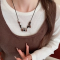 Close-up of vintage brown camera pendant necklace on a matching brown knit sweater - Black Camera Pendant (11#)
