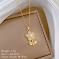 Macro shot of gold flower pendant necklace with pearls and crystals on a brown jewelry box - Flower Necklace (D541)