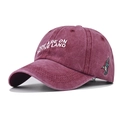 Dettaglio cappellino bordeaux in cotone lavato con ricamo bianco e toppa con colibrì laterale - Borgogna