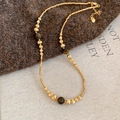 Detailed macro of 18k gold plated tiger eye stone beads on a twisted rope chain necklace - Gold Necklace with Coffee Tiger's Eye (Real Gold Plated)