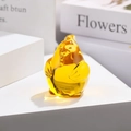 Macro shot of an amber translucent glass rooster figurine for desktop decoration - Zodiac Rooster / Gold Yellow