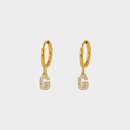 Close-up of gold-plated hoop earrings with G-letter pendant inlaid with white zircons - Letter G