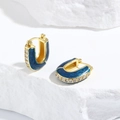 Gros plan de boucles d'oreilles en U dorées avec émail bleu et détails en zircon - Bleu foncé