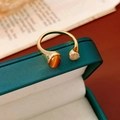 Dettaglio di un anello vintage dorato con occhio di tigre e zirconi su scatola verde - Anello - Oro